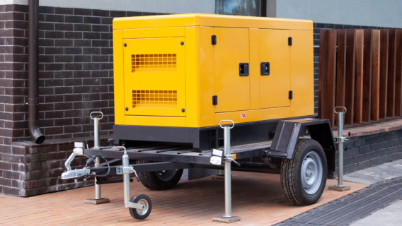 Mobile diesel charge generator on a trailer for emergency electric power standing outside of modern building