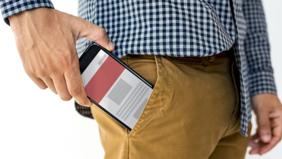 Man taking phone out of pocket with alert on screen